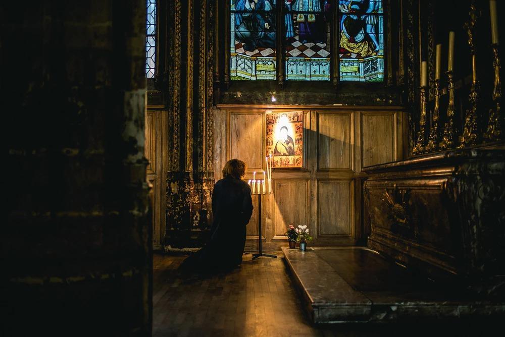 person praying in front of an altar